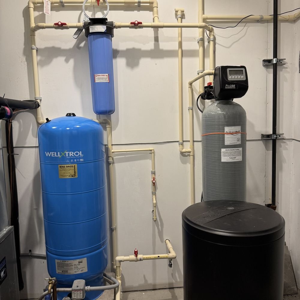 Skilled technician checking water heater controls, connections, and performance in residential utility room